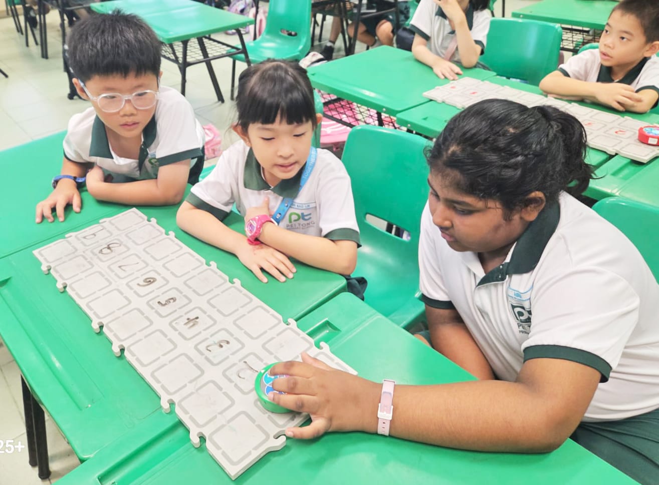 Primary 1 students work together on a screen-free coding activity, using coding cards to develop sequencing, problem-solving and teamwork skills without digital devices.